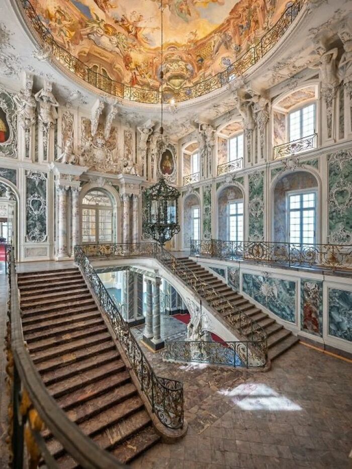 Grand baroque staircase and ornate hall, a stunning example of historical buildings with character and intricate modern designs.