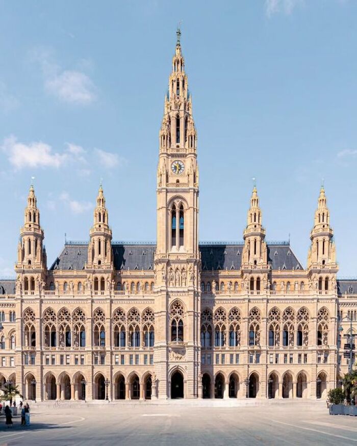 A grand, historic building with a tall central spire and ornate architecture that exudes character, surpassing modern designs.