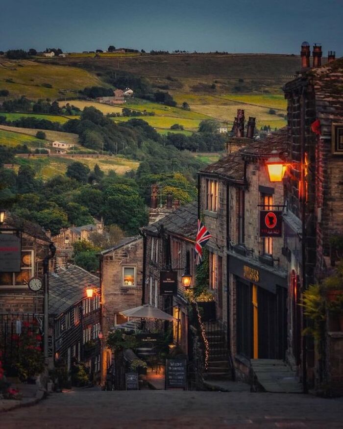 Charming historic buildings line a narrow street in a village, showcasing their distinct character.