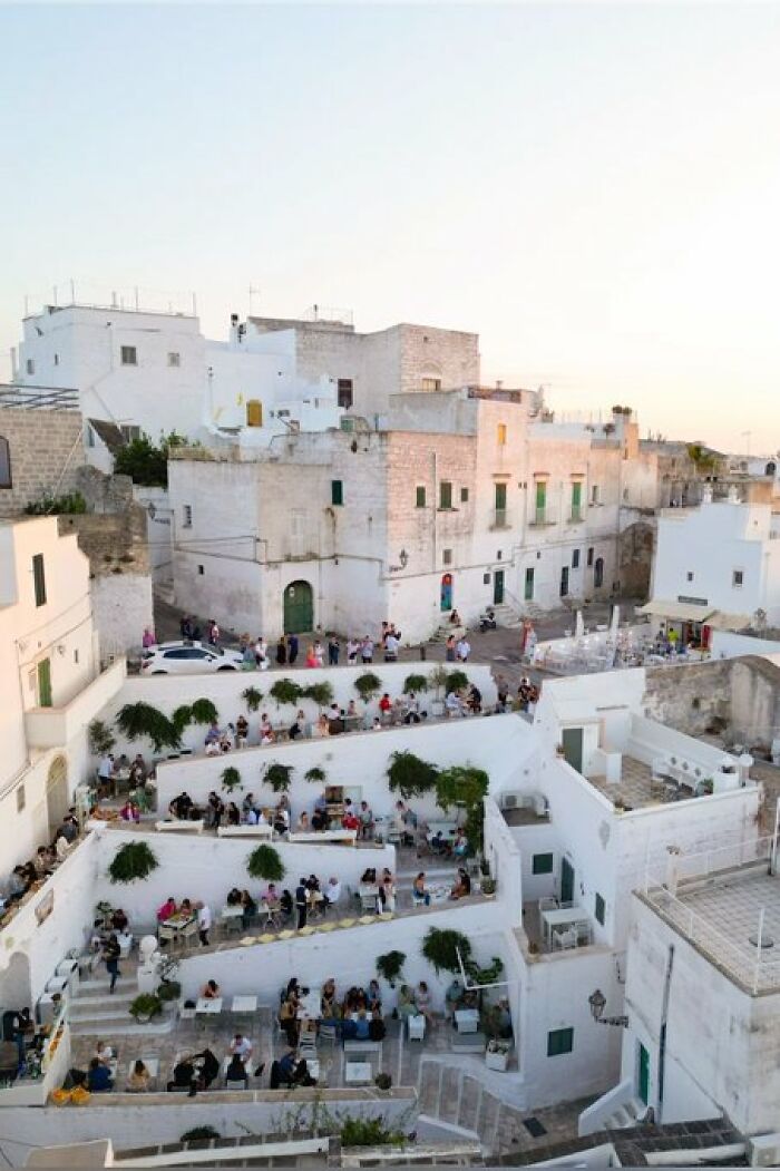 Whitewashed hillside town with outdoor dining terraces, featuring buildings with so much character and charm.