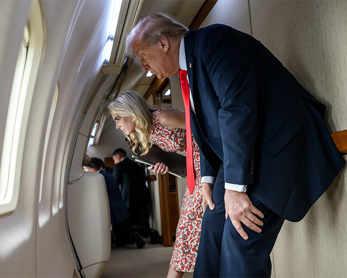 Trump and his assistant looking out of an airplane window. Scrutiny of Melania's absence from public life mounts.
