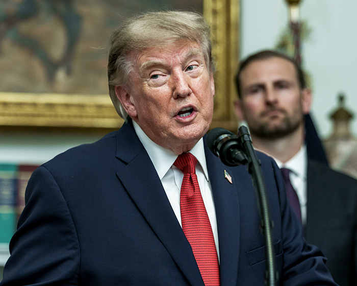 Donald Trump at a podium, speaking, as Natalie Harp appears in the background. His move amid scandal. Donald Trump at a podium, speaking, as Natalie Harp appears in the background. His move amid scandal.