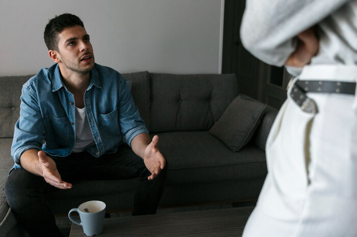 A man gesturing while talking to an unseen person, discussing why men signed divorce papers.
