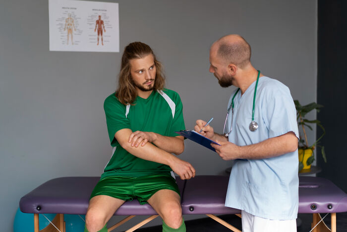 A man in a green uniform talking to a doctor, unrelated to divorce papers or fighting.