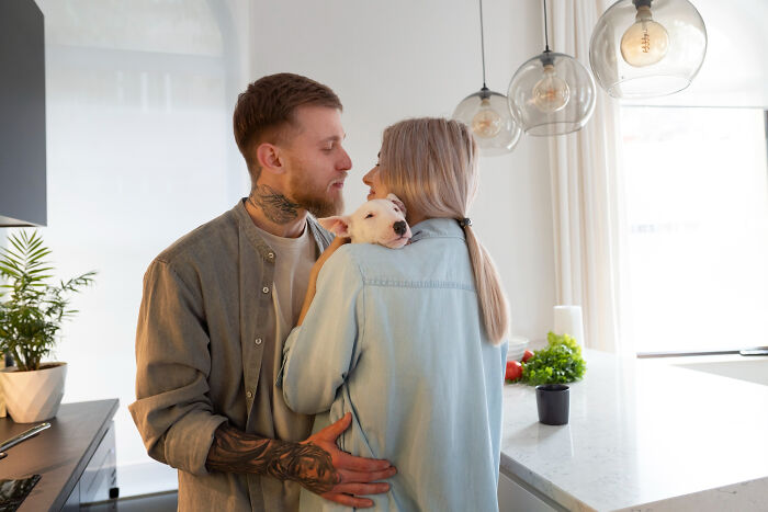 A happy couple with a dog, potentially avoiding divorce papers and fighting.