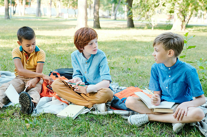 Three kids sitting on a blanket in a park, possibly discussing the bully gaslights kid situation or other school matters. Three kids sitting on a blanket in a park, possibly discussing the bully gaslights kid situation or other school matters.