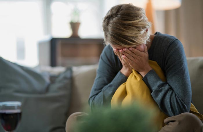 A woman crying, her face buried in her hands, highlighting MILs you wouldn't wish upon your worst enemy.