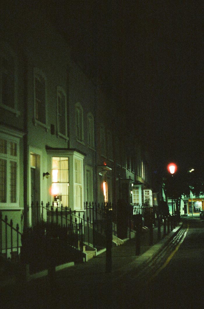 A dark street scene at night with lit windows, symbolizing the isolation of dealing with MILs you wouldn't wish upon your worst enemy.