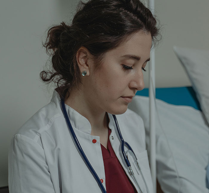 A nurse looking down, possibly reviewing patient charts, highlighting interactions where patients said weird things.