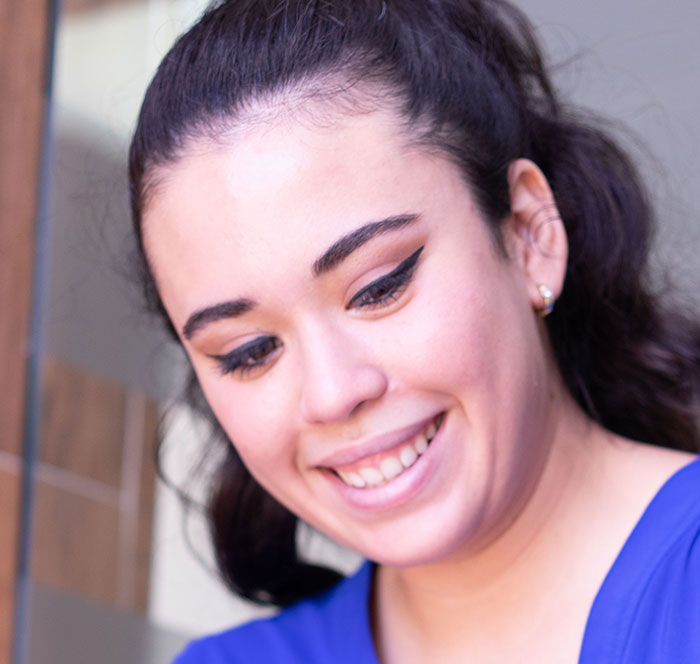 A smiling healthcare worker, possibly a nurse, interacting with patients.