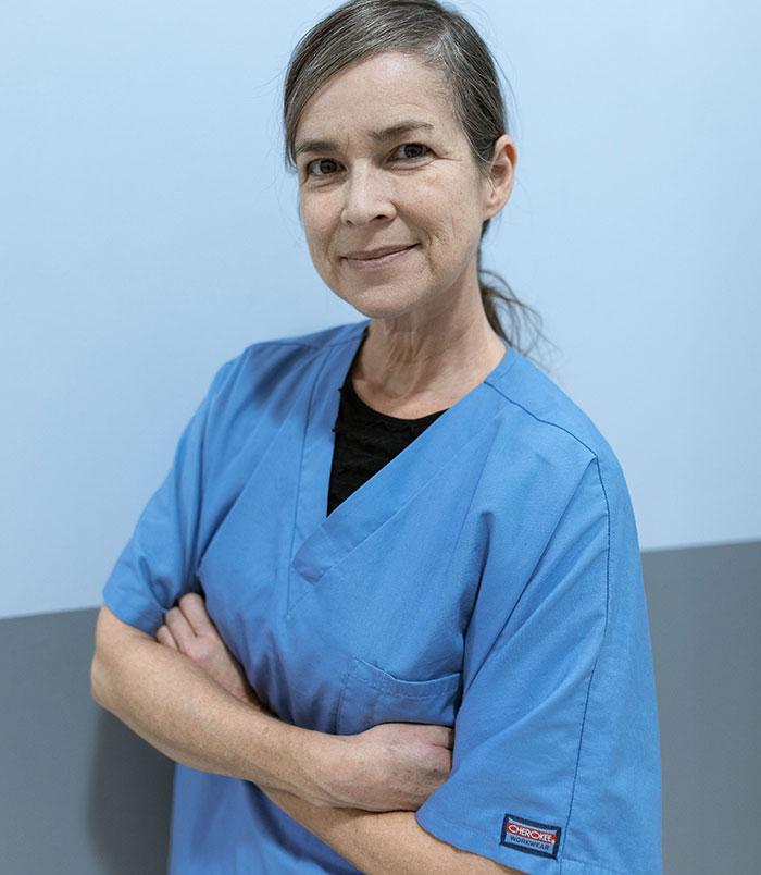 A female nurse with arms crossed, smiling, ready to hear all the weird things patients said.