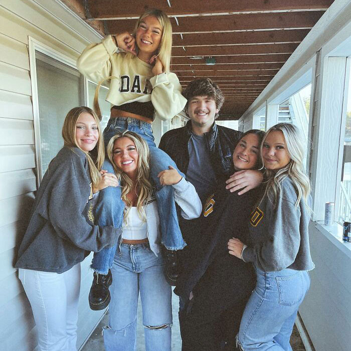 Six young adults, including the victims, posing happily on a porch. They are smiling and enjoying each other's company. Six young adults, including the victims, posing happily on a porch. They are smiling and enjoying each other's company.