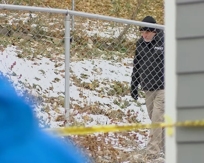 Police officer investigating the area around the house targeted by Bryan Kohberger, with snow on the ground. Police officer investigating the area around the house targeted by Bryan Kohberger, with snow on the ground.