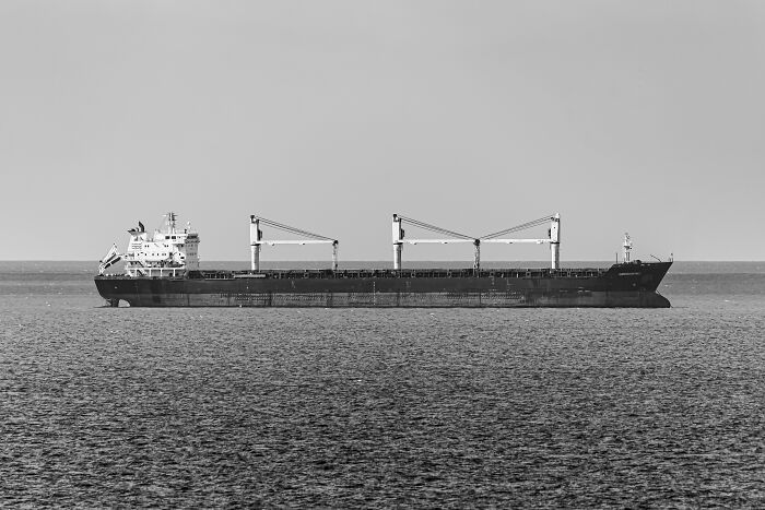 A black and white image of a large cargo ship at sea, possibly linked to fascinating WWII mysteries.