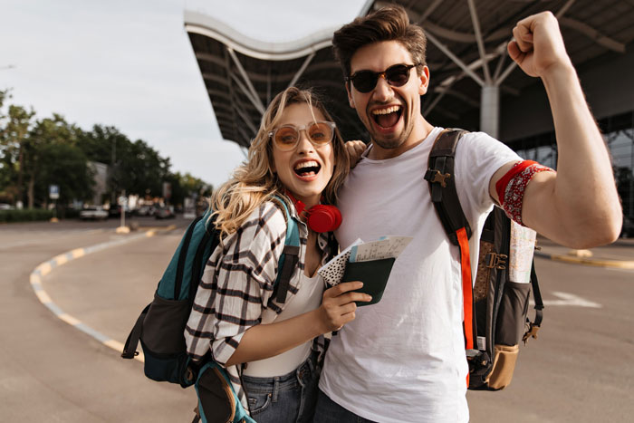 Excited couple with flight tickets, ready for a family trip and flight upgrades. Excited couple with flight tickets, ready for a family trip and flight upgrades.