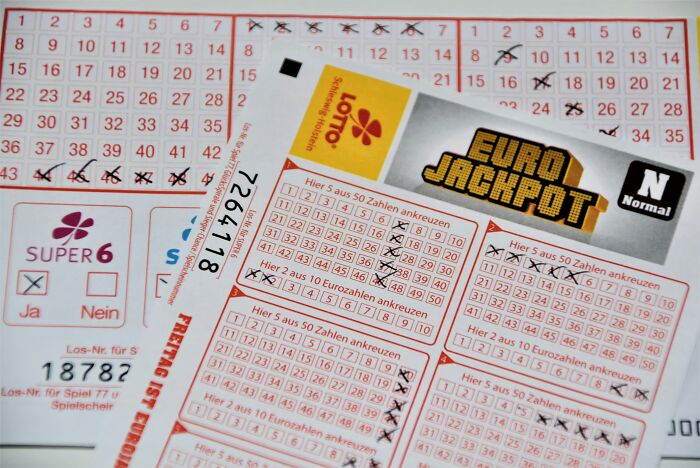 Multiple lottery tickets and a Euro Jackpot ticket, indicating a chance to win a jackpot. Multiple lottery tickets and a Euro Jackpot ticket, indicating a chance to win a jackpot.