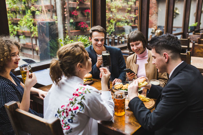 Guests at a table enjoying food and drinks, illustrating the social aspect of a wedding, contrasting with guests getting tired.