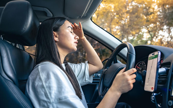 A stressed woman driving, representing guests tired of driving for a 4-venue wedding across LA.