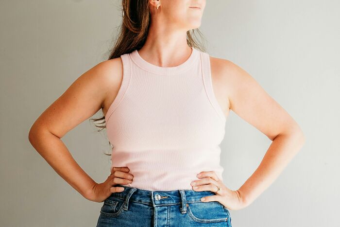A woman with her hands on her hips, standing confidently against a plain background. This image relates to cults and ADHD.