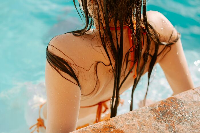 A woman with wet hair emerging from a swimming pool. This image relates to cults and ADHD.