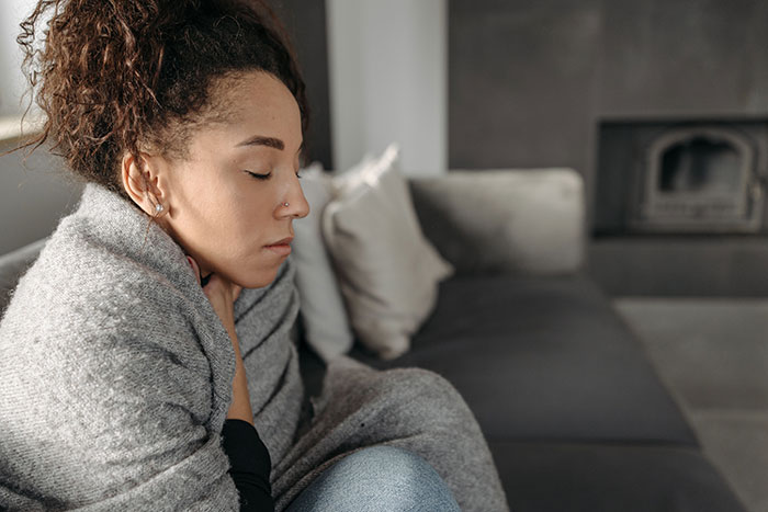 A pregnant woman, wrapped in a blanket, contemplates her husband's old messages. A pregnant woman, wrapped in a blanket, contemplates her husband's old messages.
