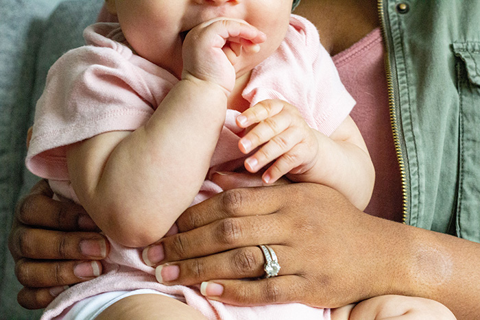 A baby is held by an adult, symbolizing the reason for a baby cam, revealing miscommunication.