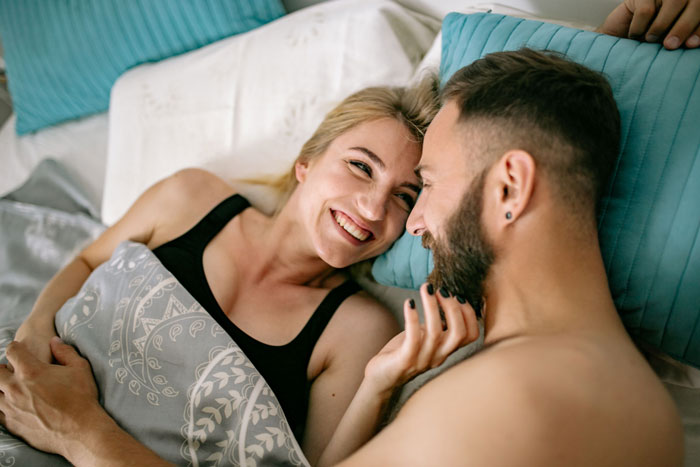 Happy couple in bed, husband and wife in an open marriage, new rules discussed after he meets another woman. Happy couple in bed, husband and wife in an open marriage, new rules discussed after he meets another woman.