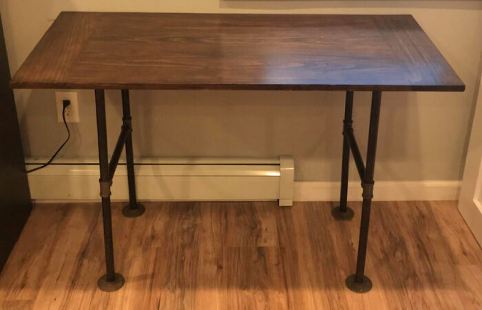 A DIY home project: a simple wooden desk with industrial pipe legs, showcasing budget-friendly DIY home projects.