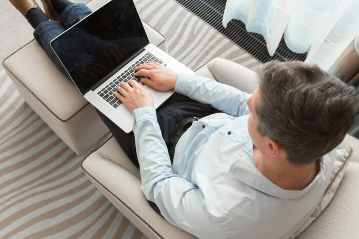 A man using a laptop, contemplating an epic comeback in a comfortable setting.