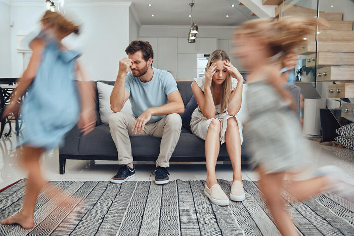 Distressed parents on a couch with two blurry children running past them. The parents look overwhelmed. Epic comebacks.