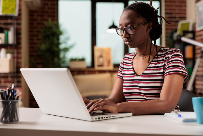 A woman on her laptop, crafting an epic comeback, focused and engaged.