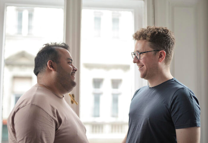 Two men smiling at each other, suggesting a friendly conversation or an exchange of epic comebacks.