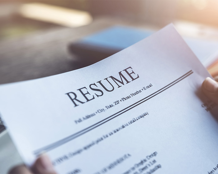 A person holding a resume, illustrating the resume botoxing trick for job applications.