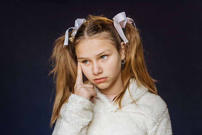 A girl, husband's kid, with pigtails and ribbons, looking thoughtful and preparing to walk away from drama. A girl, husband's kid, with pigtails and ribbons, looking thoughtful and preparing to walk away from drama.