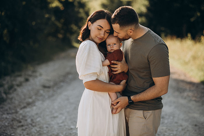 A happy family portrait of a woman, her husband, and their baby, symbolizing the love a woman hopes for in a marriage. A happy family portrait of a woman, her husband, and their baby, symbolizing the love a woman hopes for in a marriage.