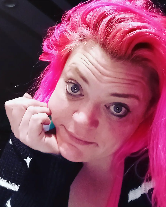 A woman with bright pink hair, possibly the woman involved in the WWII Memorial vandalism incident, looking at the camera.