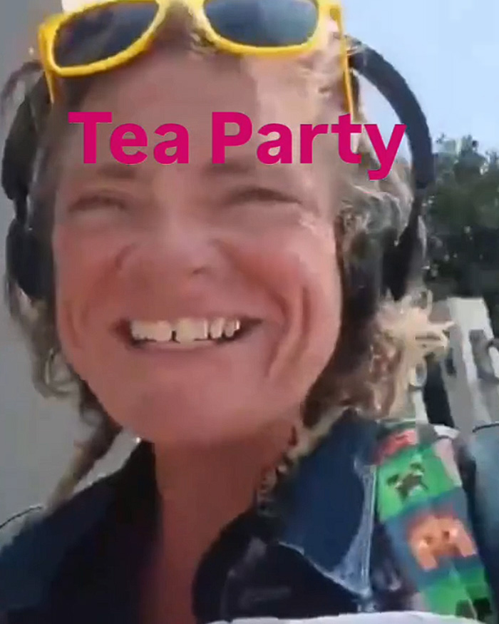 Close-up of the woman who vandalized the WWII Memorial, smiling with sunglasses on her head and headphones.