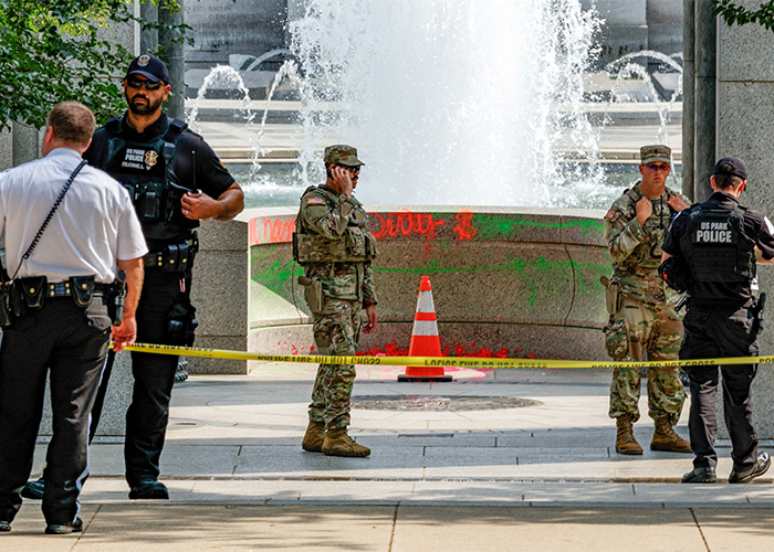 Police and military personnel secure the vandalized WWII Memorial, highlighting the serious response to the woman's actions.