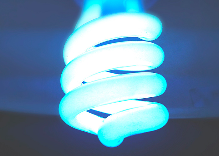 A bright, blue-glowing compact fluorescent light bulb that might be related to electric issues causing scalp sensations. A bright, blue-glowing compact fluorescent light bulb that might be related to electric issues causing scalp sensations.