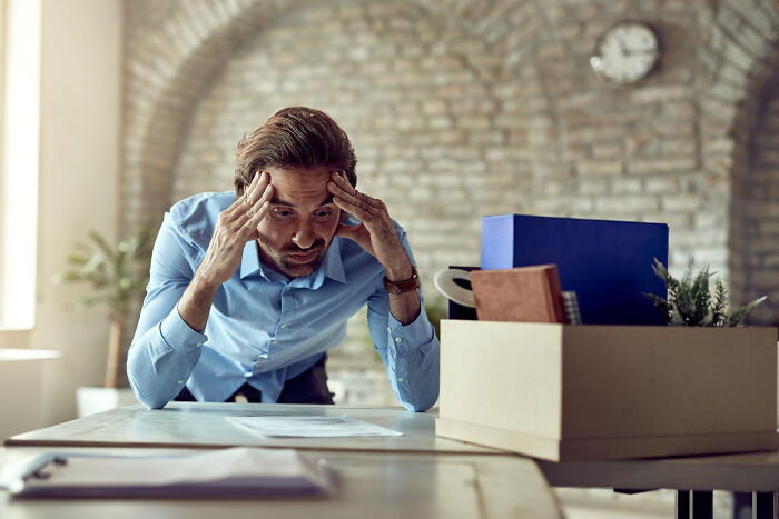 A man looking stressed at a desk with a box, illustrating the planning escape and impactful comments.