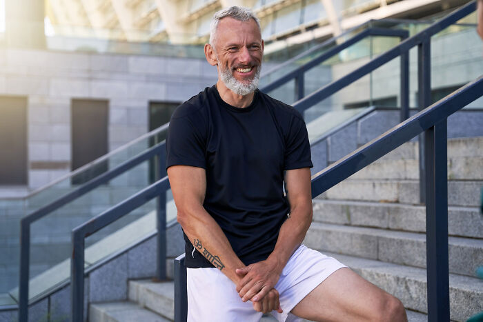 Happy man sitting on stairs, highlighting comments from women that made men go from planning date nights to planning their escape.