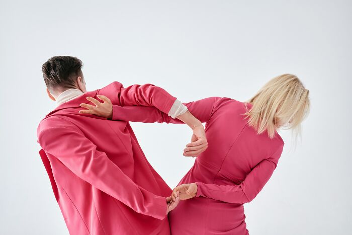 Two people in pink suits, with their backs to the camera, illustrate the worst things people put up with.