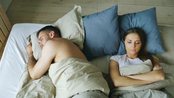 A couple in bed, the woman looking upset, illustrating women walking away from bad relationships.