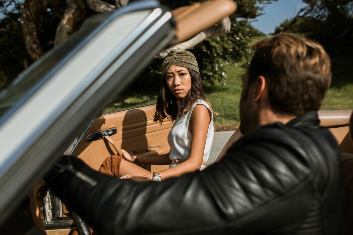 Woman in a car, looking distressed at a man, considering worst things she put up with.
