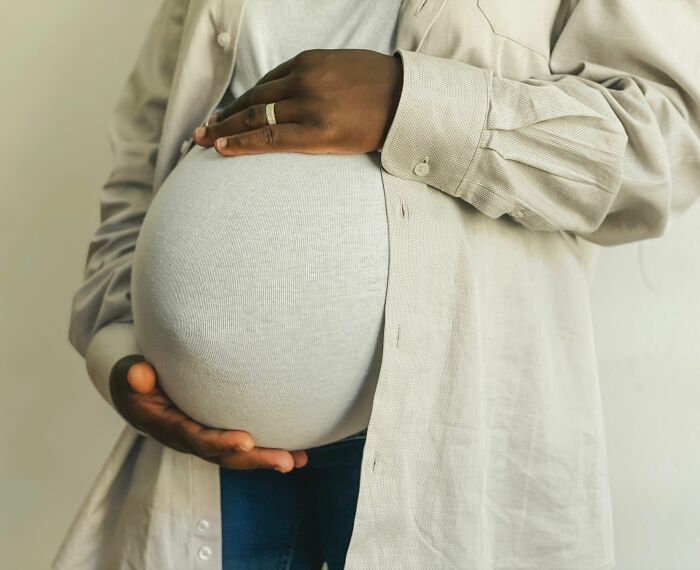 A pregnant woman holding her belly, illustrating personal journeys before women finally walking away.