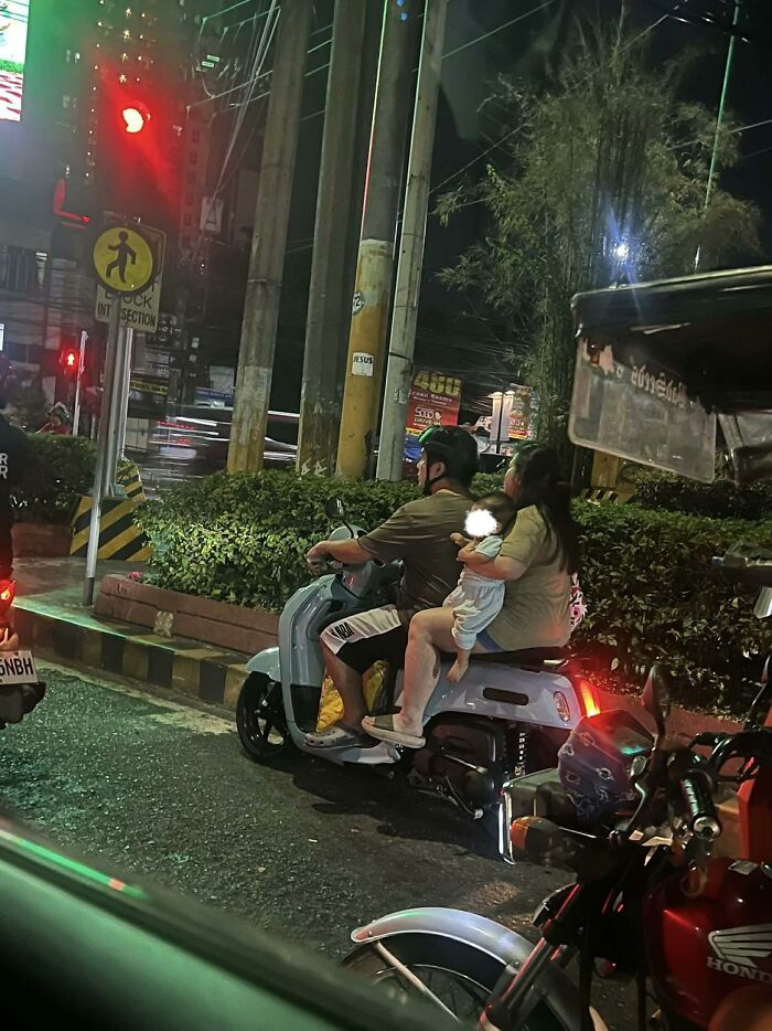 Parents on a scooter with a baby, highlighting a wrong way to solve a problem with child safety.