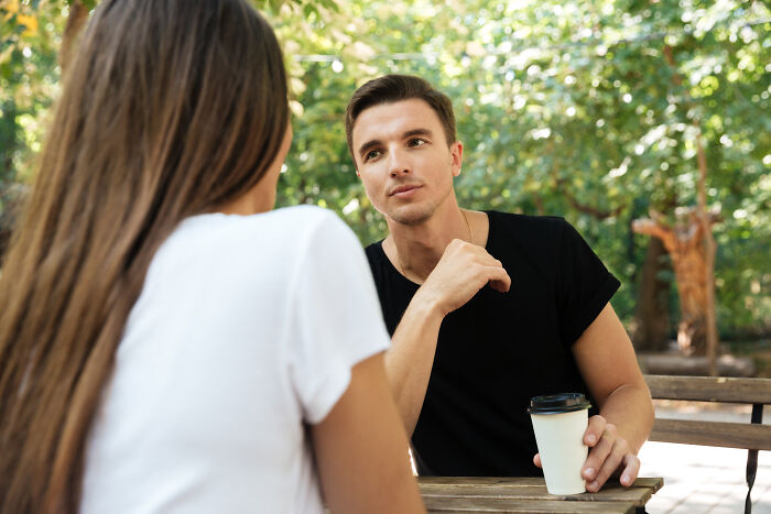 A man looks intently at a woman during a conversation, emphasizing the importance of identifying relationship red flags for mental health.