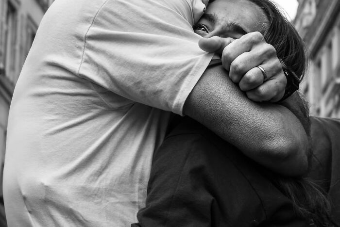 Perfectly timed street photo by Gaspard Claude revealing an unseen side of Paris: a man embracing a woman.