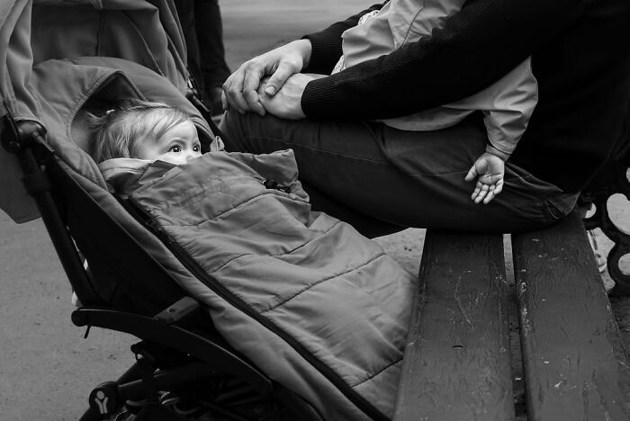 Perfectly timed street photo by Gaspard Claude capturing an unseen side of Paris: a baby in a stroller.