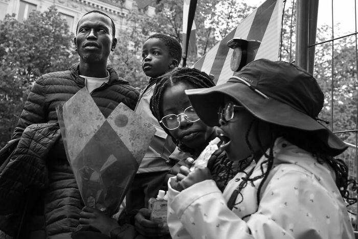 Perfectly timed street photo by Gaspard Claude depicting an unseen side of Paris: a family enjoying the street.